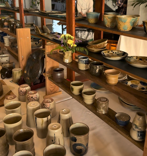 Ein modernes Wohnzimmer im Japandi- und Wabi-Sabi-Stil. Natürliche Materialien wie Holz und Keramik treffen auf helle Farben und grüne Pflanzen – ein Beispiel für die Wohntrends 2025.